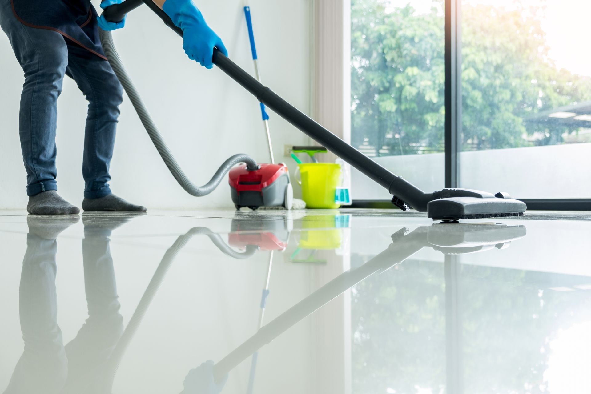 Young attractive man is cleaning vacuum commercial cleaning equipment on floor at home helping wife, builders clean, sparkle clean, sales clean, professional cleaning, contract cleaning